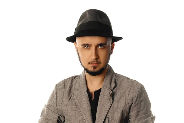 Prachtige jonge man in hat en jas kijken naar de camera — Stockfoto