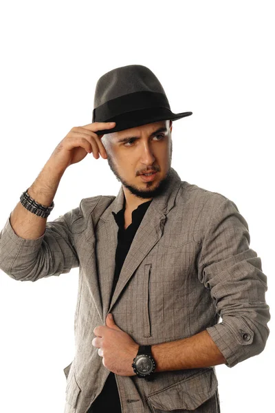 Młody przystojny mężczyzna Nieogolony w kapelusz i płaszcz patrząc od hotelu — Zdjęcie stockowe