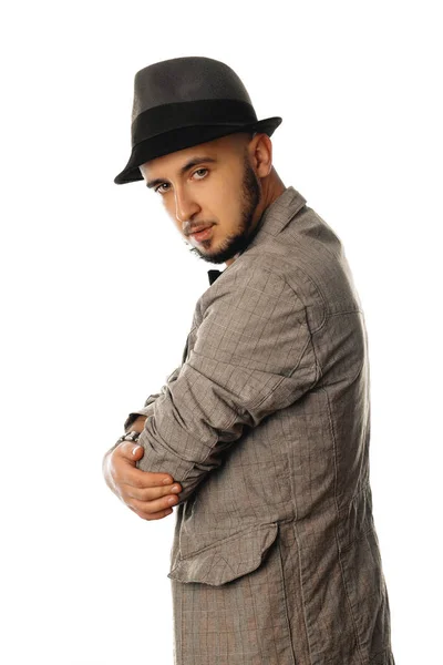 Handsome young unshaved man in hat and jacket looking away — Stock Photo, Image