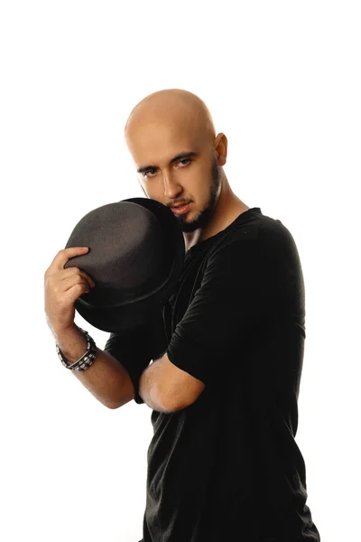 Glamour unshaved man wearing black with hat in his hands — Stock Photo, Image