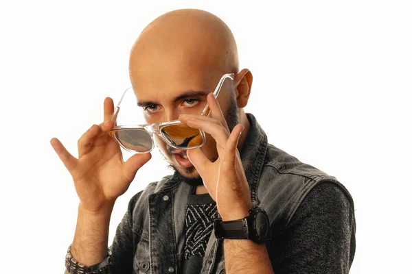 Sensual hombre sin afeitar mirando hacia otro lado con gafas de sol en sus manos —  Fotos de Stock