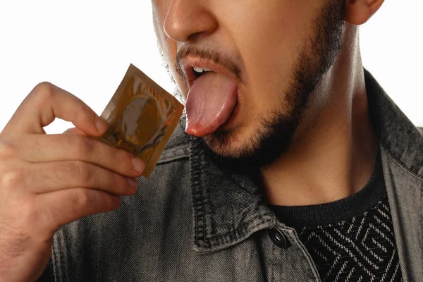 Sexy unshaved homoseksuele man met condoom in zijn mond — Stockfoto