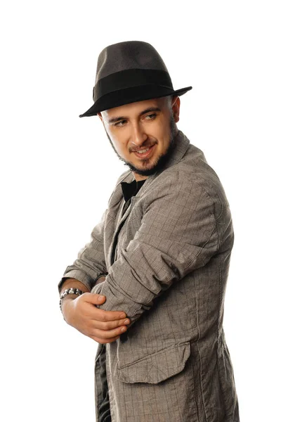 Cheerful young unshaved man in hat and jacket looking away — Stock Photo, Image