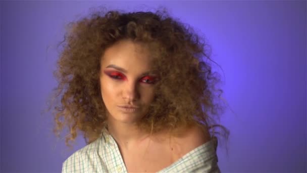 Beautiful young girl with fluffy curly hair and colourful makeup — Stock Video