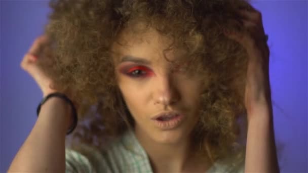 Mooi jong meisje met pluizig krullend haar en kleurrijke make-up — Stockvideo