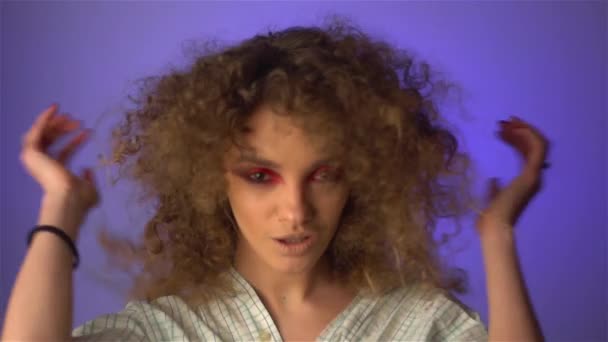Mooi jong meisje met pluizig krullend haar en kleurrijke make-up — Stockvideo