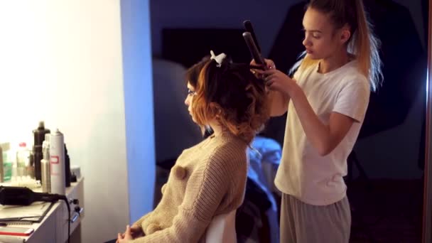 Menina estilista jovem faz penteado para uma senhora — Vídeo de Stock