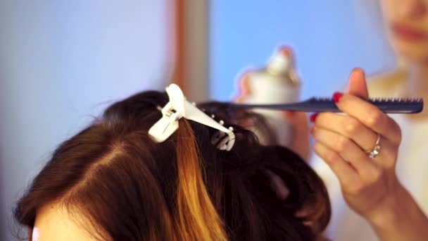 Unga stylist flicka gör frisyr till en dam — Stockvideo