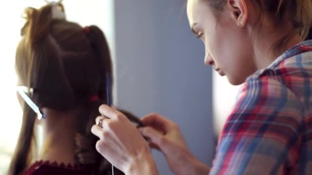 Gadis penata rambut pirang membuat gaya rambut untuk seorang wanita muda — Stok Video