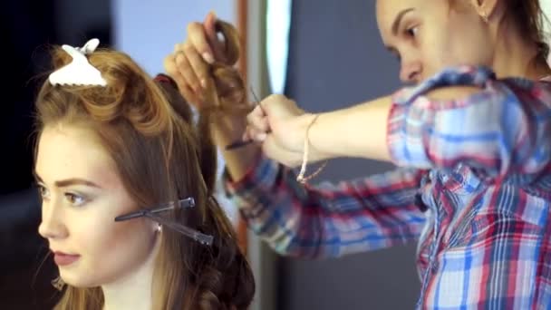 Szőke stylist lány frizuráját tesz egy fiatal nő — Stock videók