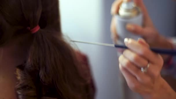 Chica estilista rubia hace peinado a una mujer joven — Vídeo de stock