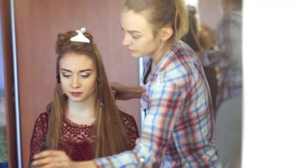 Szőke stylist lány frizuráját tesz egy fiatal nő — Stock videók