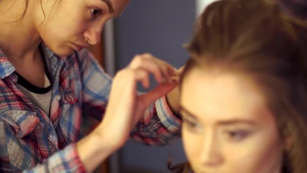 Στυλίστας ξανθιά κοπέλα κάνει χτένισμα σε μια νεαρή γυναίκα — Αρχείο Βίντεο
