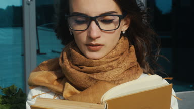 Genç sevimli kız bardaklarda bir kitap okuma