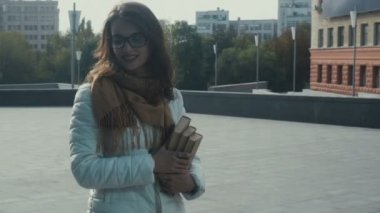 sokak ve gülümser el kitaplarında genç neşeli esmer kadınla yürüyor