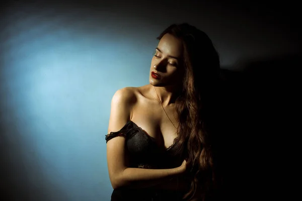 Prachtige dame met krullend kapsel in donkere studio — Stockfoto