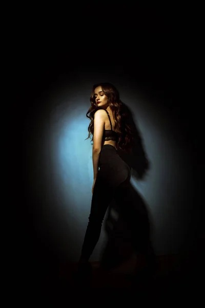 Preciosa dama con peinado rizado en estudio oscuro — Foto de Stock