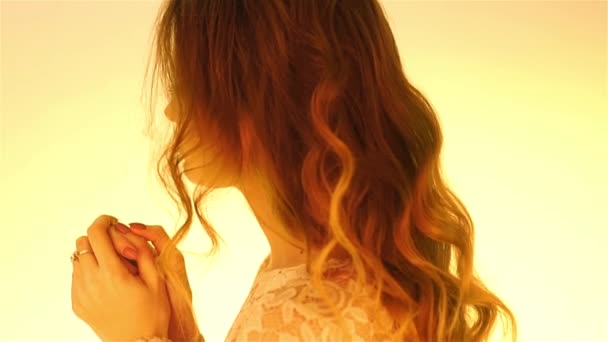 Молодая каштановые волосы девушка в теплых желтых огнях позирует — стоковое видео