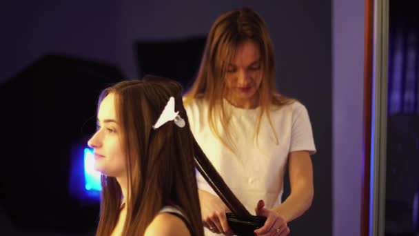 Jovem cabeleireiro fazer penteado com mulher bonita — Vídeo de Stock