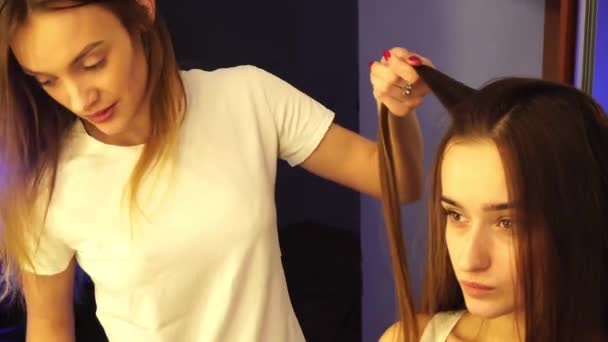 Молодий стиліст волосся робить зачіску з красивою жінкою — стокове відео
