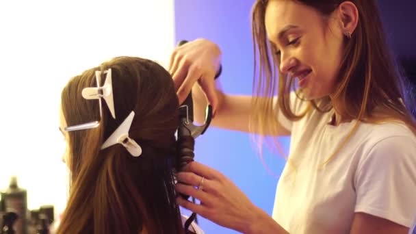 Joven estilista de pelo hacer peinado con hermosa mujer — Vídeo de stock