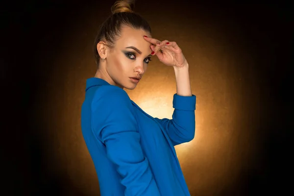 Hermosa joven en chaqueta azul con maquillaje de belleza en el estudio — Foto de Stock