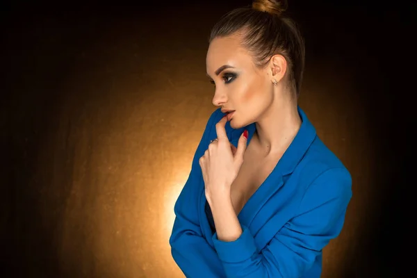 Hermosa joven en chaqueta azul con maquillaje de belleza en el estudio — Foto de Stock