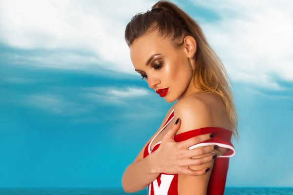 Sexy junges Mädchen im roten Body-Badeanzug am Strand — Stockfoto