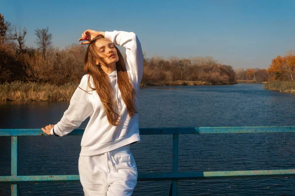 Schönes Mädchen in weißen Kleidern steht auf der Brücke — Stockfoto