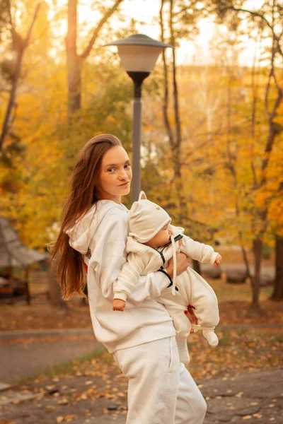 Hermosa joven mamá con bebé en otoño — Foto de Stock