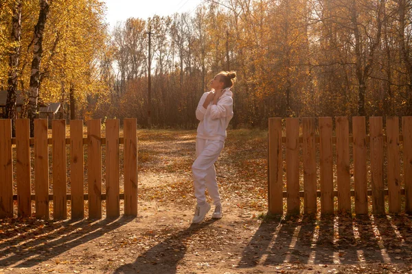 Ragazza si trova vicino a una recinzione di legno in autunno — Foto Stock