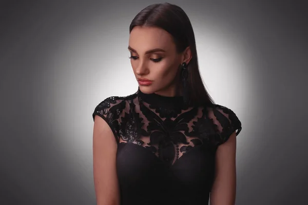 Sexy young lady in black dress in studio — Stock Photo, Image