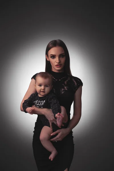 Sexy young mother with little baby girl in studio — Stock Photo, Image