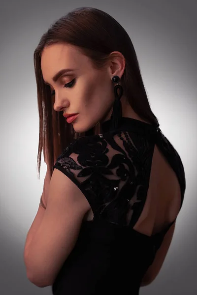 Sexy jonge dame in zwart jurk in studio — Stockfoto