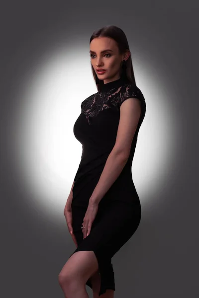 Sexy young lady in black dress in studio — Stockfoto