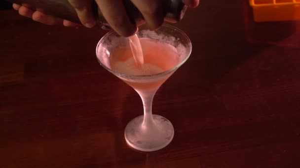 Man pours drink into cocktail glass — Stock Video