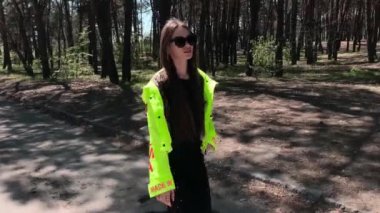 Havalı genç kız ormanda yürüyor.