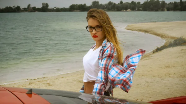 Πανέμορφη Ξανθιά Γυαλιά Στέκεται Στο Κόκκινο Αυτοκίνητο Στην Παραλία — Φωτογραφία Αρχείου