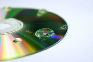 Beyaz zemin üzerinde bir damla su olan cd