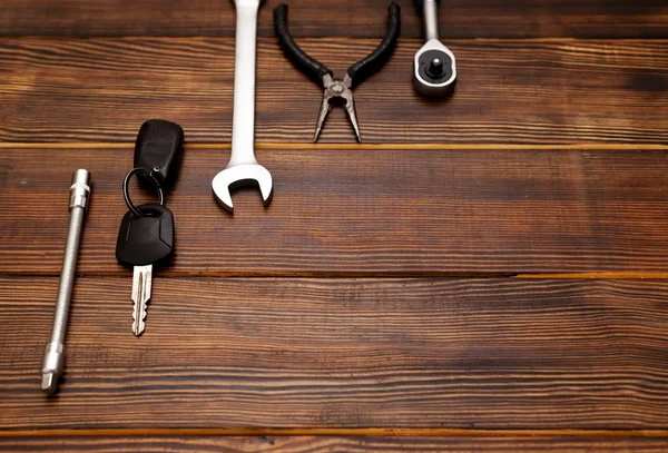 New keys on wooden background, top view on car keys and repair — 스톡 사진