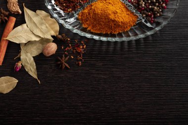 Kristaldeki siyah ahşap arka planda baharatlar