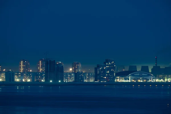 Khabarovsk, Russia - Oct 24, 2019: Night View of the city of Khabarovsk from the Amur river. Blue night sky. The night city is brightly lit with lanterns. — Stock Photo, Image