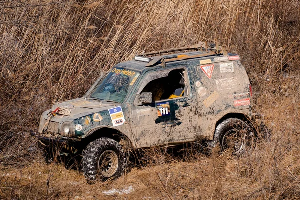 Khabarovsk, Rusland - 11 nov 2019: Jeep Suzuki Jimny overwint obstakels in het bos. — Stockfoto