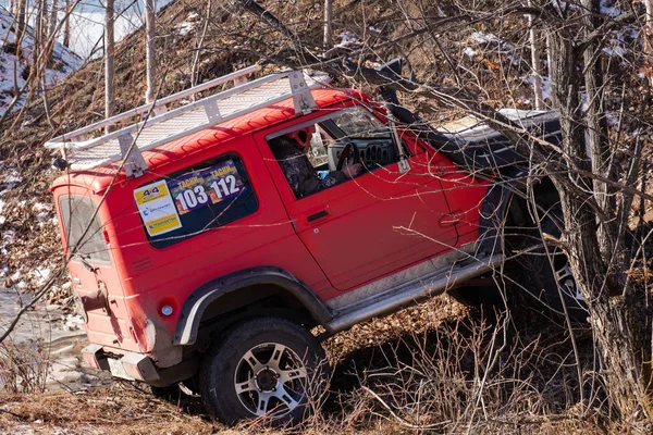 Khabarovsk, Rusland - 11 nov 2019: Jeep Suzuki Jimny overwint obstakels in het bos. — Stockfoto