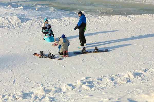 Khabarovsk, Rússia - 04 de dezembro de 2016: A instrutora treina uma adolescente e um homem snowboard . — Fotografia de Stock