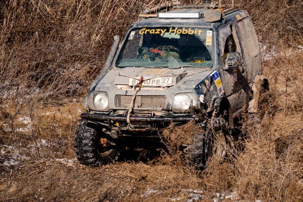 Chabarowsk, Rosja - 11 listopada 2019: Jeep Suzuki Jimny pokonuje przeszkody w lesie. — Zdjęcie stockowe