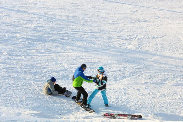 Khabarovsk, Rússia - 04 de dezembro de 2016: A instrutora treina uma adolescente e um homem snowboard . — Fotografia de Stock