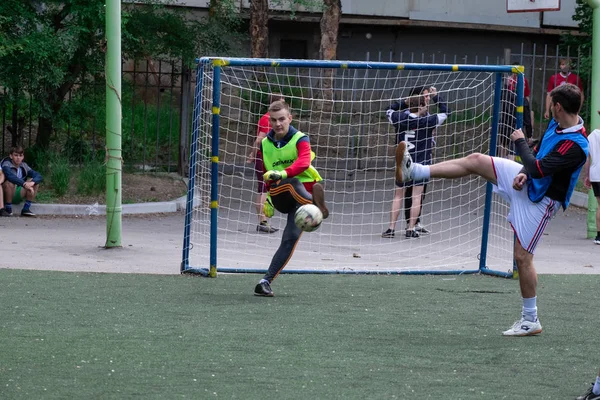 Rosja, Chabarowsk - 11 czerwca 2019: street domestic playing soccer. Młodzi grają w piłkę na zielonej trawie. — Zdjęcie stockowe