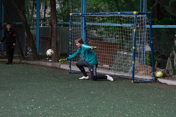 Rosja, Chabarowsk - 11 czerwca 2019: street domestic playing soccer. Młodzi grają w piłkę na zielonej trawie. — Zdjęcie stockowe