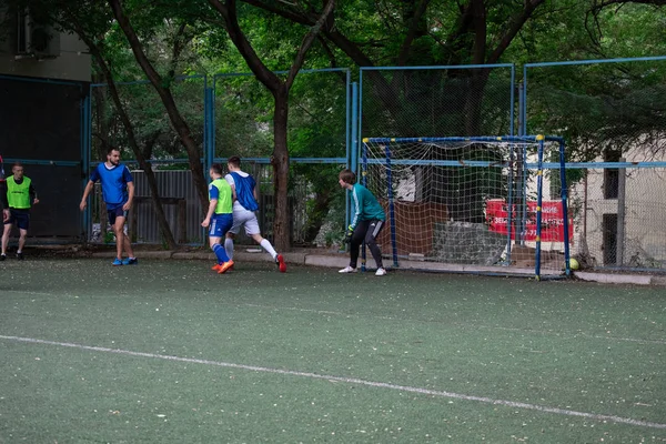 Россия, Хабаровск - 11 июня 2019 года: уличный футбол. Молодые парни играют в футбол на зеленой траве — стоковое фото